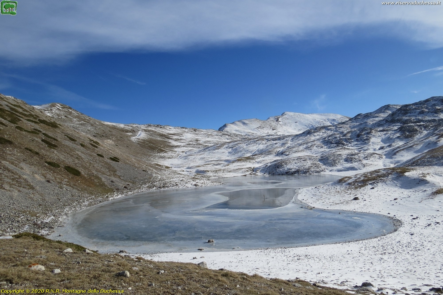 Il lago ghiacciato con poca neve ad imbiancare le praterie circostanti